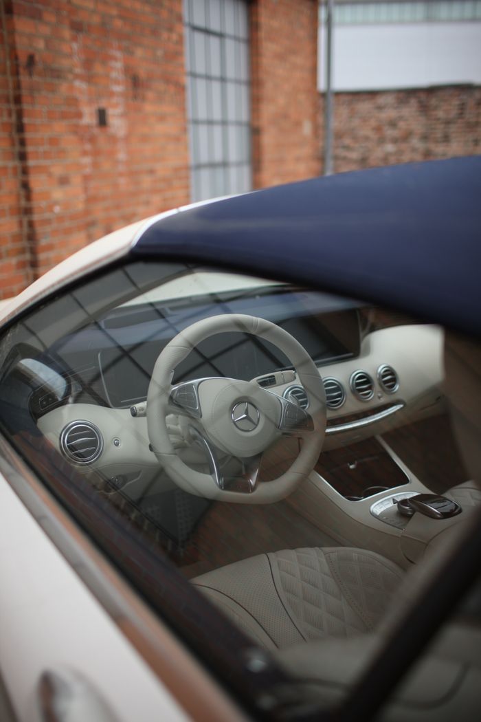 Detailed shot of a Mercedes-Benz convertible interior with focus on the steering wheel and dashboard.