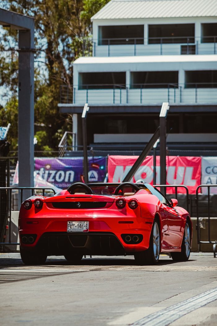 A sleek red sports car parked in a city setting, showcasing luxury and style.